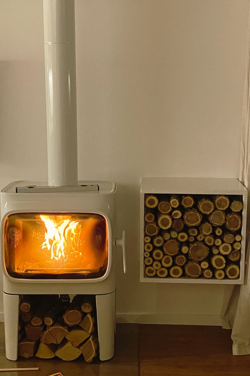 Krbové kachle Jotul s ohňom a poukladaným drevom v stene
